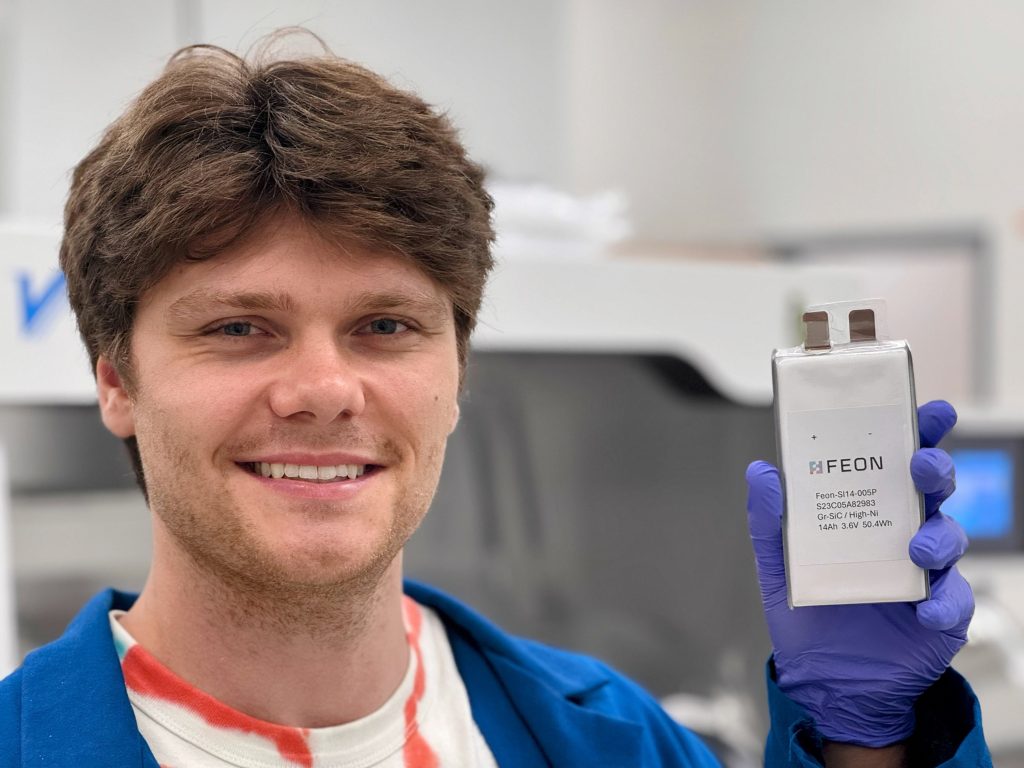 A staff member of Feon Energy showing an advanced battery utilising Feon’s AI-discovered electrolyte.